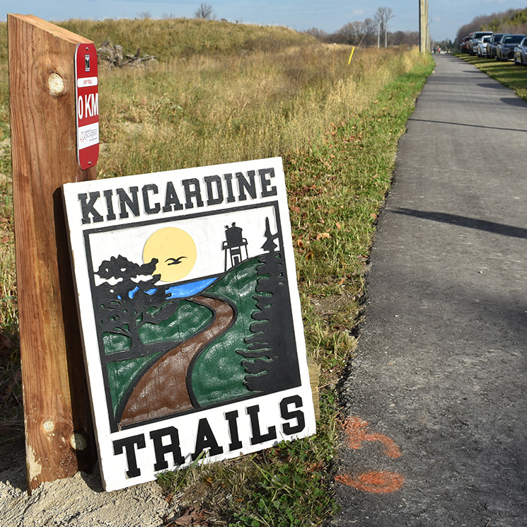 A Kincardine Trails sign leans against a post on the KIPP Trail.