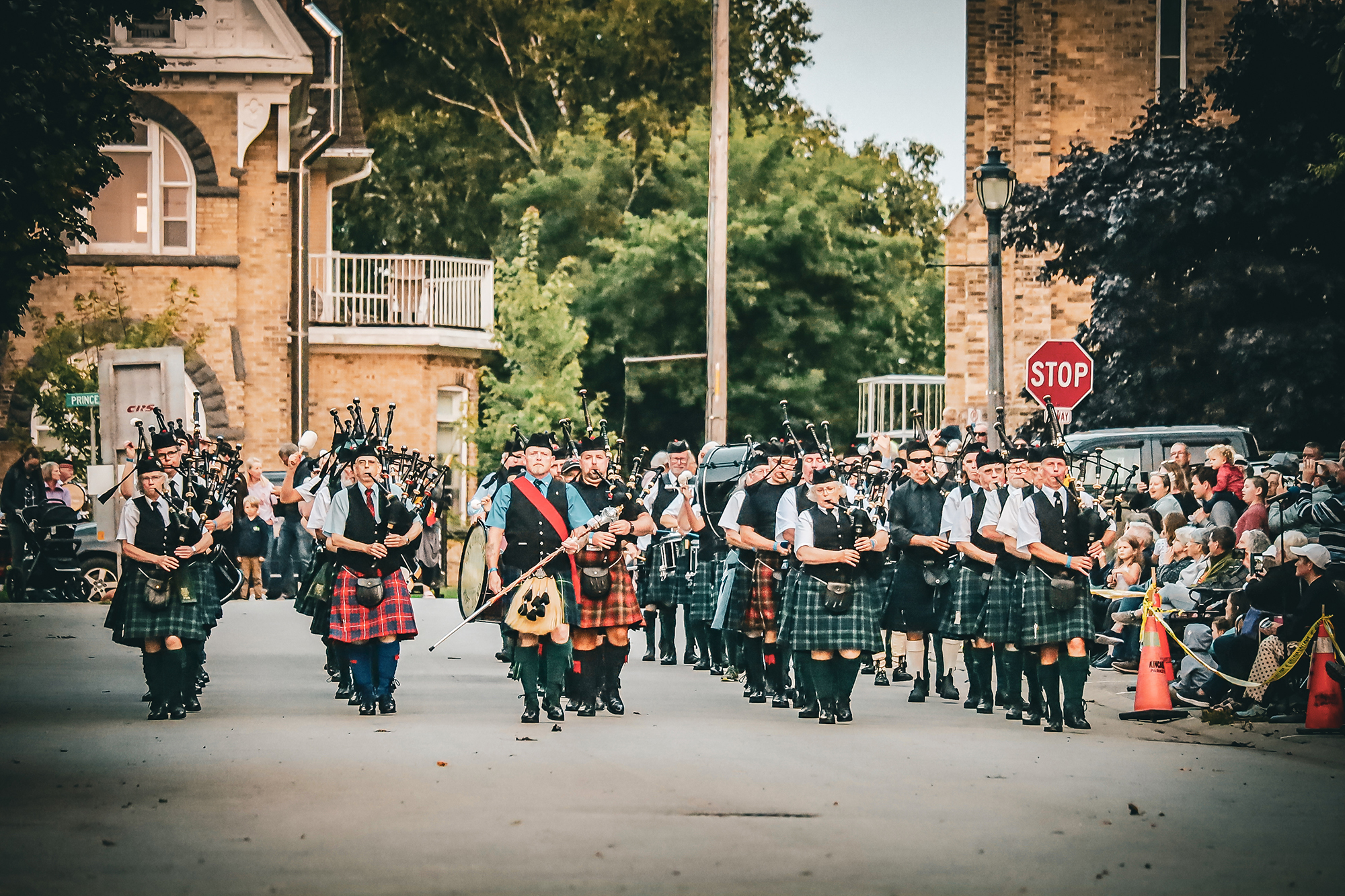 A massed pipe band marches.