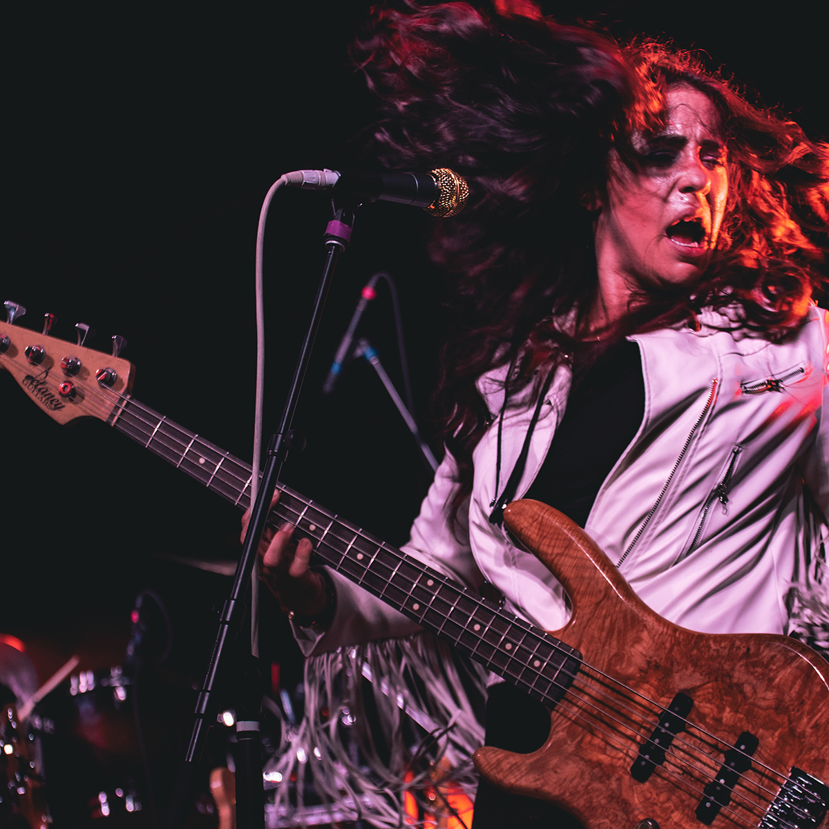 A performer dances while holding her electric bass at the Lighthouse Blues Festival.